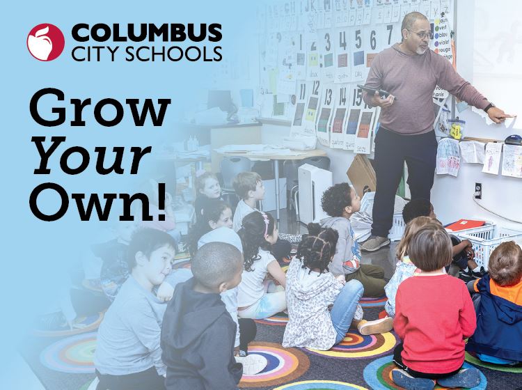 Teacher pointing at board while students look up at him from the floor